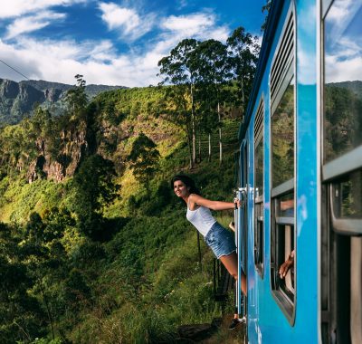 Beautiful girl traveling by train among mountains. The girl travels by train to beautiful places. Travel by train. Travelling to Asia. Trains Sri Lanka. Railway transport. Railway. Transport Asia